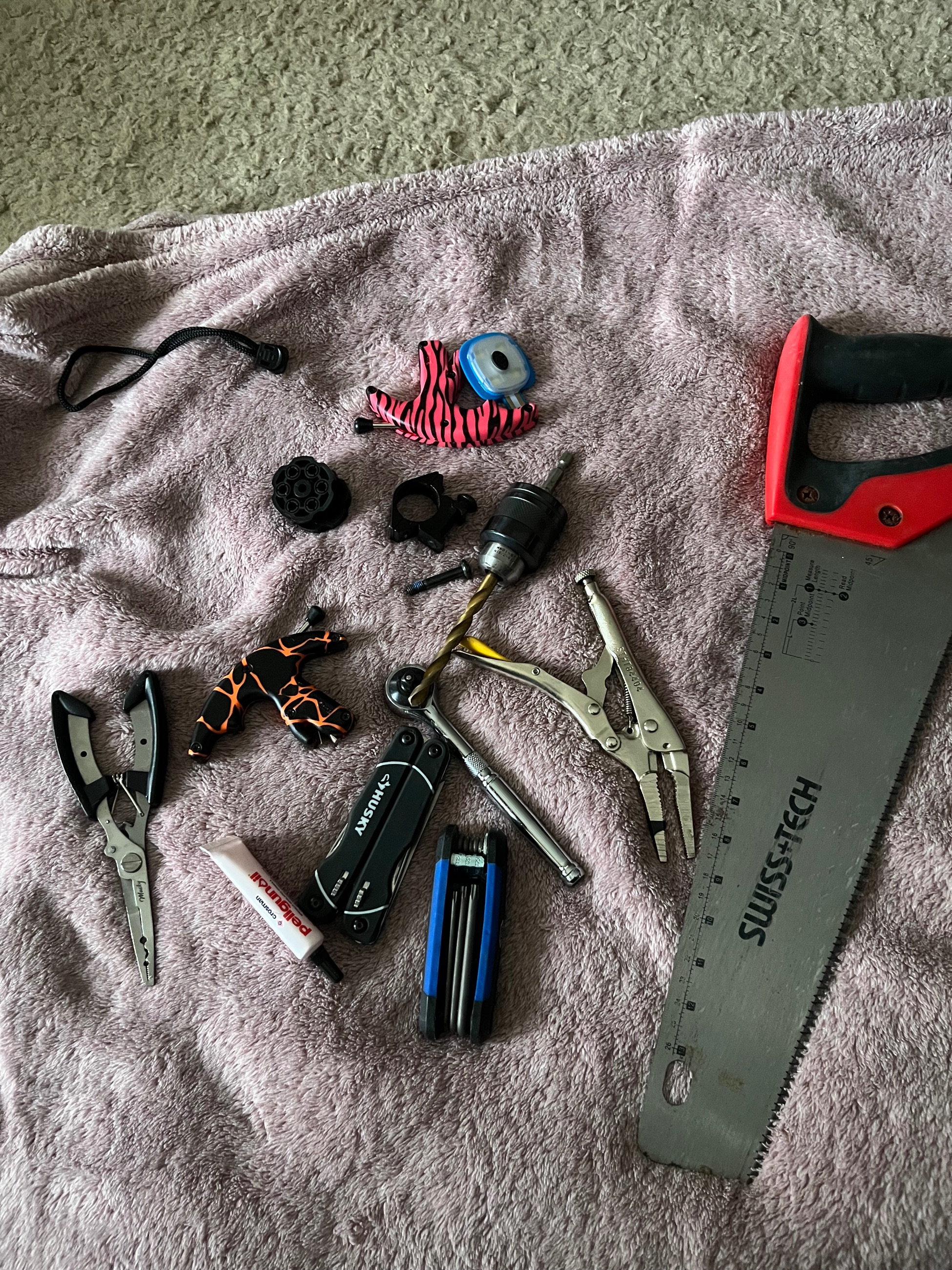 Photo of Assorted Tools Including Saw, Pliers, and Multi-tool